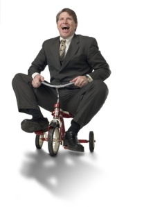 Executive riding child's tricycle